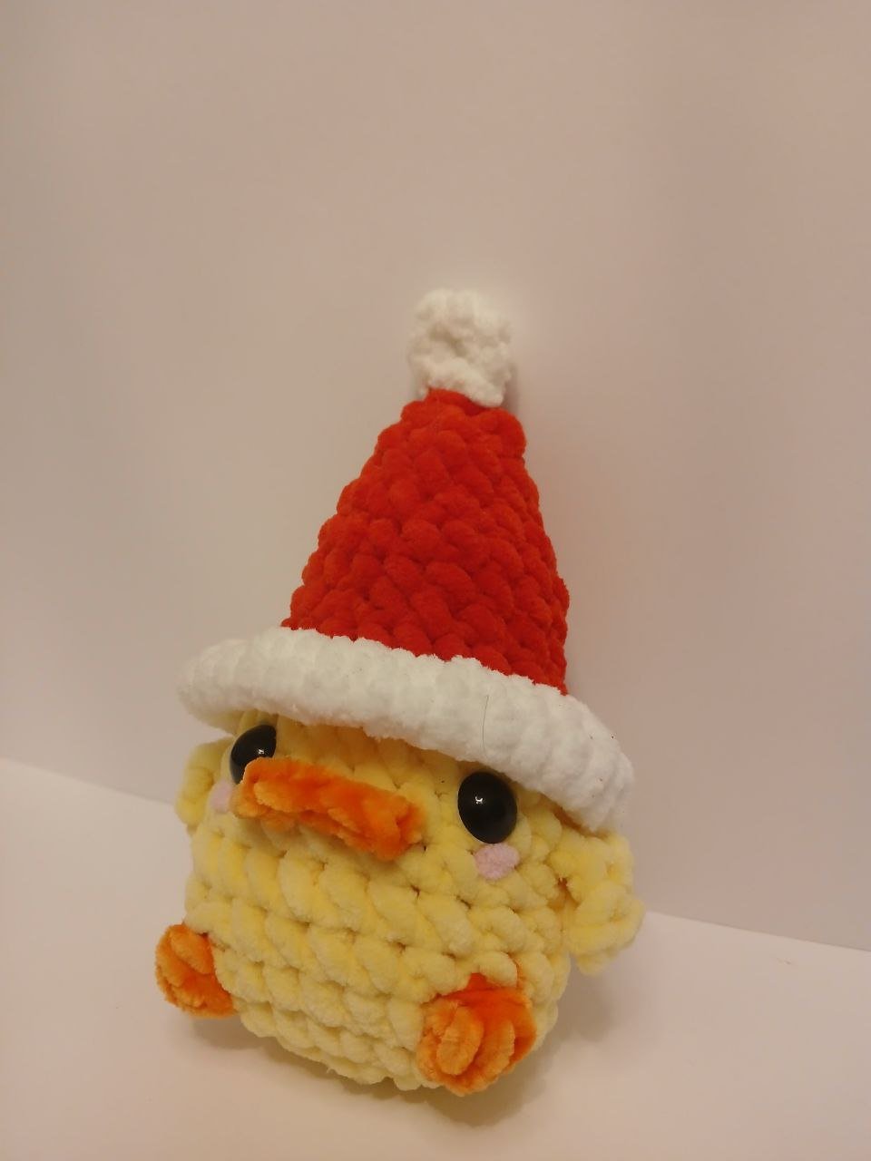 Patinho de croché com o chapéu de Pai Natal vermelho.